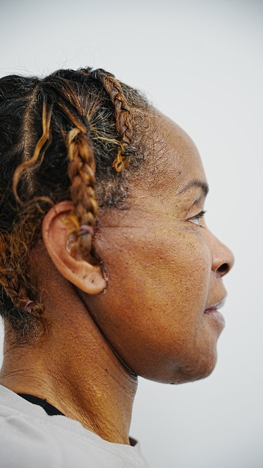 Profile of a woman with curly short hair.