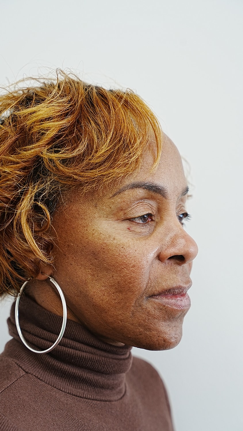 Profile of a woman with curly short hair.
