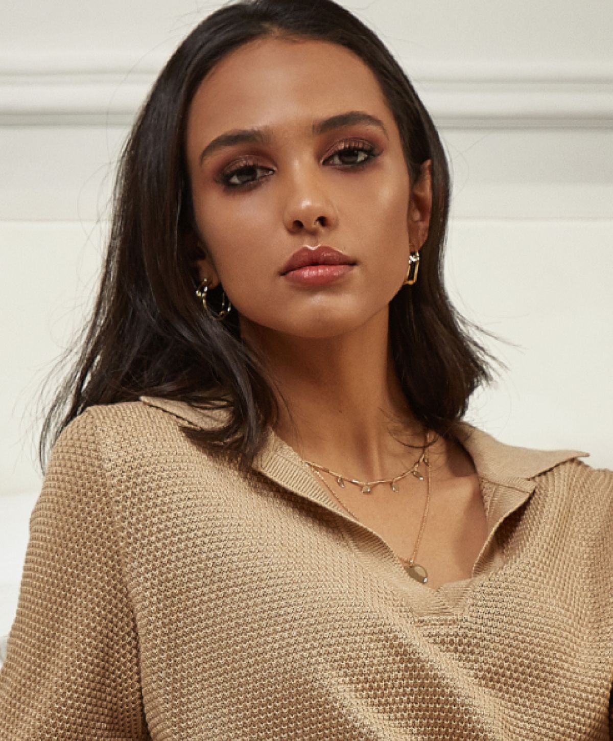 Young woman in beige sweater, casual elegant look.