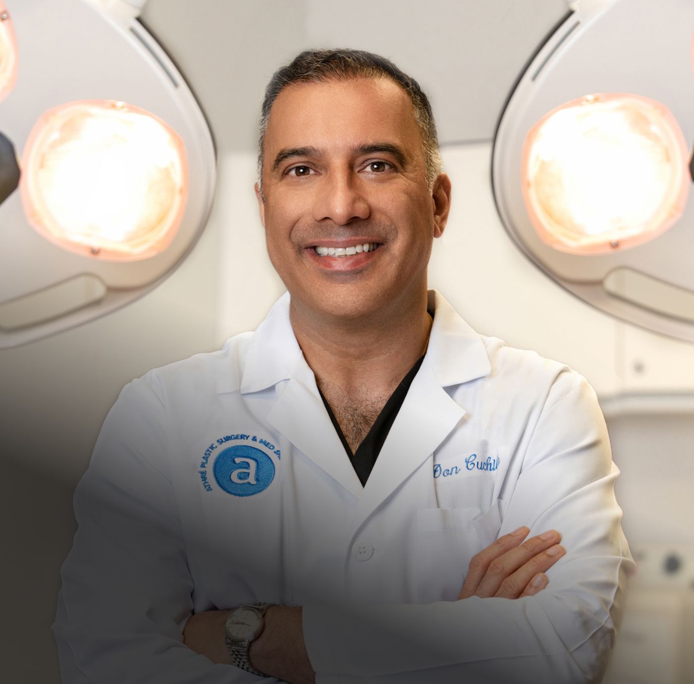 Doctor smiling in surgery room with lights.