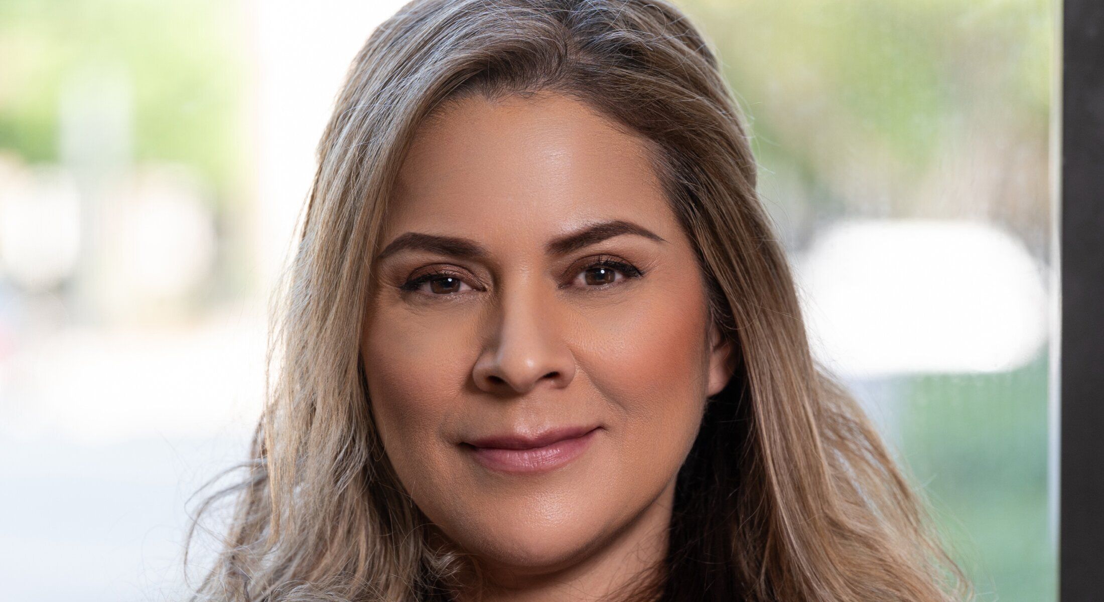 Portrait of a woman with long, wavy hair.