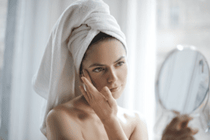 woman with hair in towel washing her face