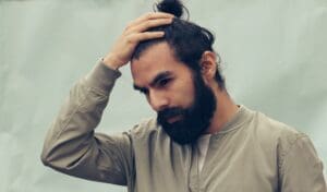 man with bearded pushing back his hair