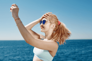 woman in sunglasses and holding hair back