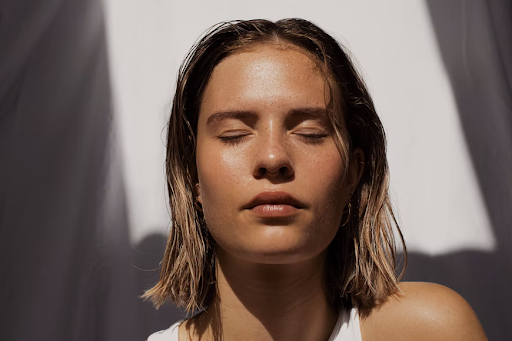 woman with clear skin closes her eyes