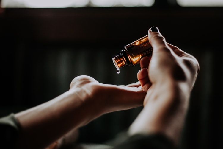 hand dropping facial serum into other hand